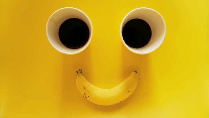 smiling face two paper cups coffee with banana yellow background 1 1