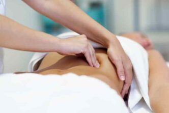 woman having abdomen massage by professional osteopathy therapist 1